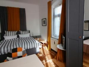 1 dormitorio con 2 camas y ventana en Am Elbradweg - Nichtraucher-Gästezimmer Weiland en Dresden