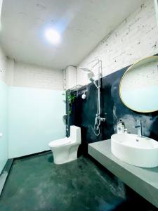 bagno con servizi igienici, lavandino e specchio di May's house (Nhà của Mây) a Hanoi