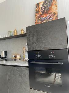 a black oven in a kitchen next to a counter at Больница Управ делами президента , IT Университет, Центр репродукции, Экспо Mega Silkway, Аэропорт in Prigorodnyy