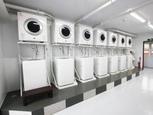 a row of white washers and dryers on a wall at AMAWARI HOTEL -SEVEN Hotels and Resorts- in Uruma