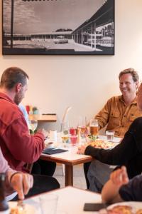 un grupo de personas sentadas alrededor de una mesa comiendo en Riverfront Motel & Villas, en Hobart