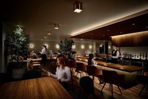 grupa ludzi siedzących przy stolikach w barze w obiekcie Hotel Grand Bach Kyoto Select w mieście Kioto