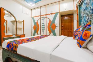een slaapkamer met 2 bedden en een spiegel bij FabHotel Rest & Peace in Ahmedabad