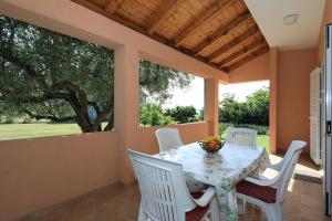 una sala da pranzo con un tavolo e sedie bianche di Holiday home Maslina a Nin