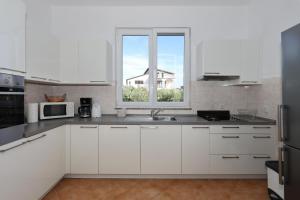 una cucina bianca con lavandino e finestra di Holiday home Maslina a Nin Altre 38 foto
