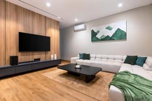 ein Wohnzimmer mit einem weißen Sofa und einem Flachbildfernseher in der Unterkunft Alex Villas Complex N3 in Canggu