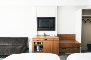 a living room with a couch and a flat screen tv at Vessel Hotel Campana Okinawa in Chatan