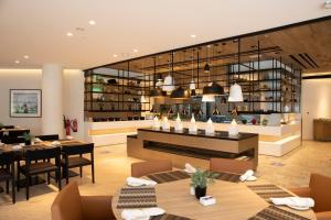 un restaurant avec des tables et des chaises ainsi qu'une salle à manger dans l'établissement Fujairah Rotana Resort & Spa - Al Aqah Beach, à Al Aqah