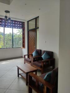 a living room with couches and a table and a window at ExoticaHolidays in Sultan Bathery