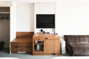 北谷町的住宿－沖繩坎帕納船舶酒店，带沙发和平面电视的客厅