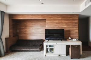 a living room with a couch and a flat screen tv at Vessel Hotel Campana Okinawa in Chatan