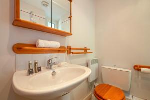 een badkamer met een wastafel, een toilet en een spiegel bij Résidence Bel'Alp 16 - Happy Rentals in Chamonix-Mont-Blanc