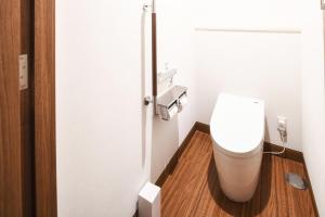 a small bathroom with a toilet and a wooden floor at Vessel Hotel Campana Okinawa in Chatan