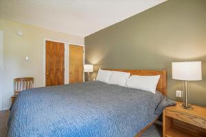 a bedroom with a bed with a blue blanket and white pillows at Pinnacle B04 in Killington +32 photos