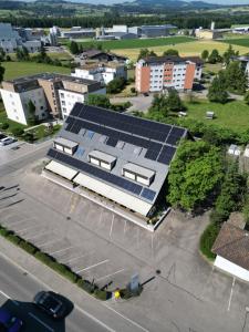 uma vista superior de um edifício com painéis solares sobre ele em Landgasthof Lowen em Sulgen