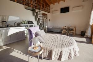 a bedroom with a large bed and a kitchen at La Finestra Sul Mondo in Marano sul Panaro