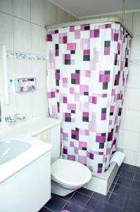 ein Bad mit einem WC und einem Duschvorhang in der Unterkunft Landgasthof Lowen in Sulgen