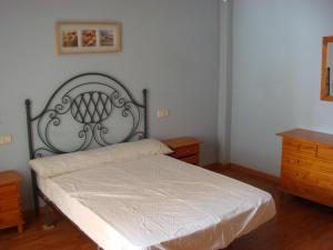 a bedroom with a bed with a white bedspread at Apartamentos Azahar in Puente de Génave