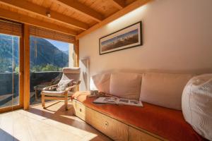 ein Schlafzimmer mit einem Sofa, einem Stuhl und einem Fenster in der Unterkunft Résidence Grand Roc - Campanules 213 - Happy Rentals in Chamonix-Mont-Blanc