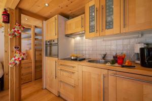 eine Küche mit Holzschränken und einem Waschbecken in der Unterkunft Résidence Grand Roc - Campanules 213 - Happy Rentals in Chamonix-Mont-Blanc