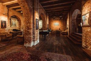 a large room with brick walls and a room with chairs at Promenade Hotel Liepaja in Liepāja