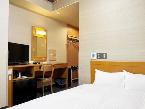 大垣市にあるホテルルートイン大垣インターのベッドルーム1室(ベッド1台、デスク、コンピュータ付)