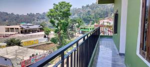 a balcony of a building with a view of a city at Limewood homestay in Almora
