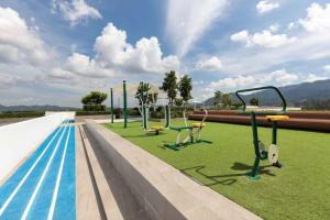 une piscine avec balançoires et herbe à côté d'une piscine dans l'établissement Greenery Views 1 BR Laguna SkyLine Apartment B2512 just 10 min walk Bangtao Beach, à Laguna Phuket