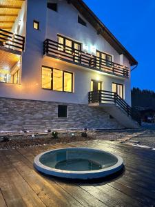 a large house with a large blue circle in front of it at Cabana FloriDeea in Scrind-Frăsinet