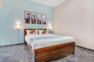 ein Schlafzimmer mit einem Bett mit zwei Bildern an der Wand in der Unterkunft OYO Home Royal Salem in Kakkayam