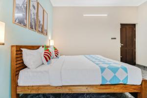 ein Schlafzimmer mit einem großen Bett mit weißer Bettwäsche und Kissen in der Unterkunft OYO Home Royal Salem in Kakkayam