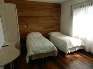 1 dormitorio con 2 camas y ventana en Aroma Verde Hotel, en Valdivia