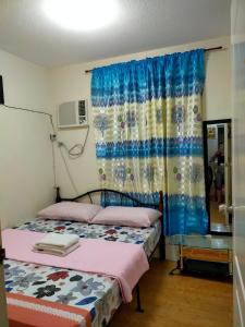 - une chambre avec 2 lits et une fenêtre dans l'établissement Two-Bedroom at San Remo Oasis, à Cebu