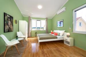 um quarto verde com uma cama e uma cadeira em KAIROS em Bilice