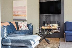 a living room with a blue couch and a table at Tamar Valley Treetop Retreat with River Views in Grindelwald
