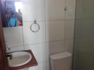 Ein Mann fotografiert ein Badezimmer mit Toilette. in der Unterkunft Estalagem Vovô Elias in São Miguel dos Milagres + 21 Fotos