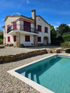 a villa with a swimming pool in front of a house at Villa Mas Fa Susa 3 étoiles avec piscine in Les Vans