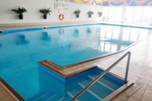 a large swimming pool with blue water in a building at Stilvolles Panorama-Appartement in Zirkitz