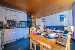 a kitchen and dining room with a wooden table at Residence de Lognan- Les Jorasses 26 - Happy Rentals in Chamonix-Mont-Blanc