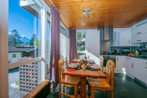 a kitchen and dining room with a table and chairs at Residence de Lognan- Les Jorasses 26 - Happy Rentals in Chamonix-Mont-Blanc