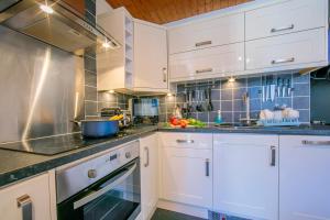 a kitchen with white cabinets and blue tiles at Residence de Lognan- Les Jorasses 26 - Happy Rentals in Chamonix-Mont-Blanc