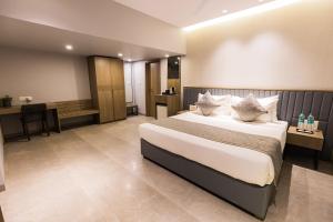 una camera d'albergo con un letto e una scrivania di The Augusta Club & Resort a Limodra