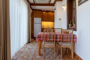 y cocina con mesa, sillas y nevera. en Ionia House, en Selçuk