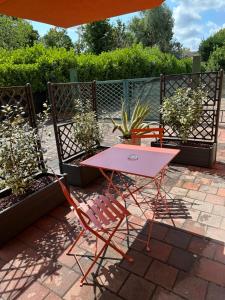 einen rosa Tisch und zwei Stühle auf einer Terrasse in der Unterkunft Villa Trevisi - APARTMENT in Treviso