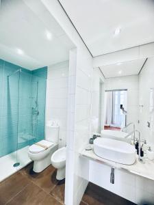 een badkamer met een wastafel, een toilet en een douche bij La Siesta in La Maddalena