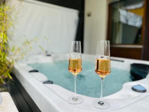 乌尔丁根-米赫尔霍芬Seehaus Aachblick, Exklusive Appartements und Ferienwohnungen的浴缸旁坐两杯葡萄酒