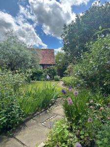 a garden with flowers in front of a house at Garden Cottage in Henley on Thames