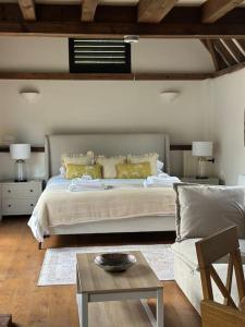a bedroom with a bed and a couch and a table at Garden Cottage in Henley on Thames +15 photos