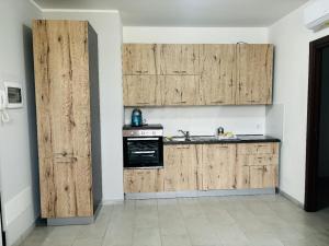 a kitchen with wooden cabinets and a stove at Matis Appartamenti in Camisano