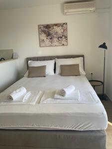 1 cama blanca grande con 2 almohadas en Apartmani Tomaš, en Tučepi